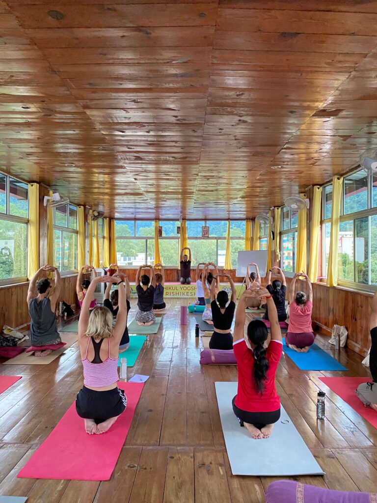 Group Yoga Session in a Bright, Wooden Yoga Hall A yoga class in a spacious wooden-floored room with large windows