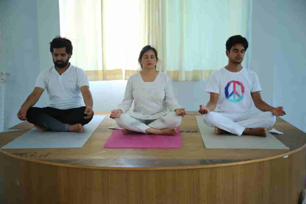 Yoga Trainer with Students Practicing Meditation Techniques Yoga Trainer with Students Practicing Meditation Techniques