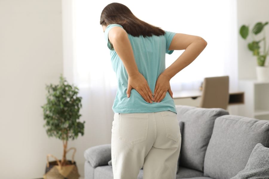Woman holding lower back in pain Woman holding lower back in pain