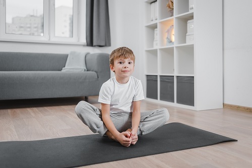 Kid Performing Butterfly Pose (Baddha Konasana) Kid Performing Butterfly Pose (Baddha Konasana)