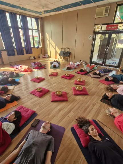 Student performing Corpse Pose (Savasana) during yoga teacher training in Rishikesh