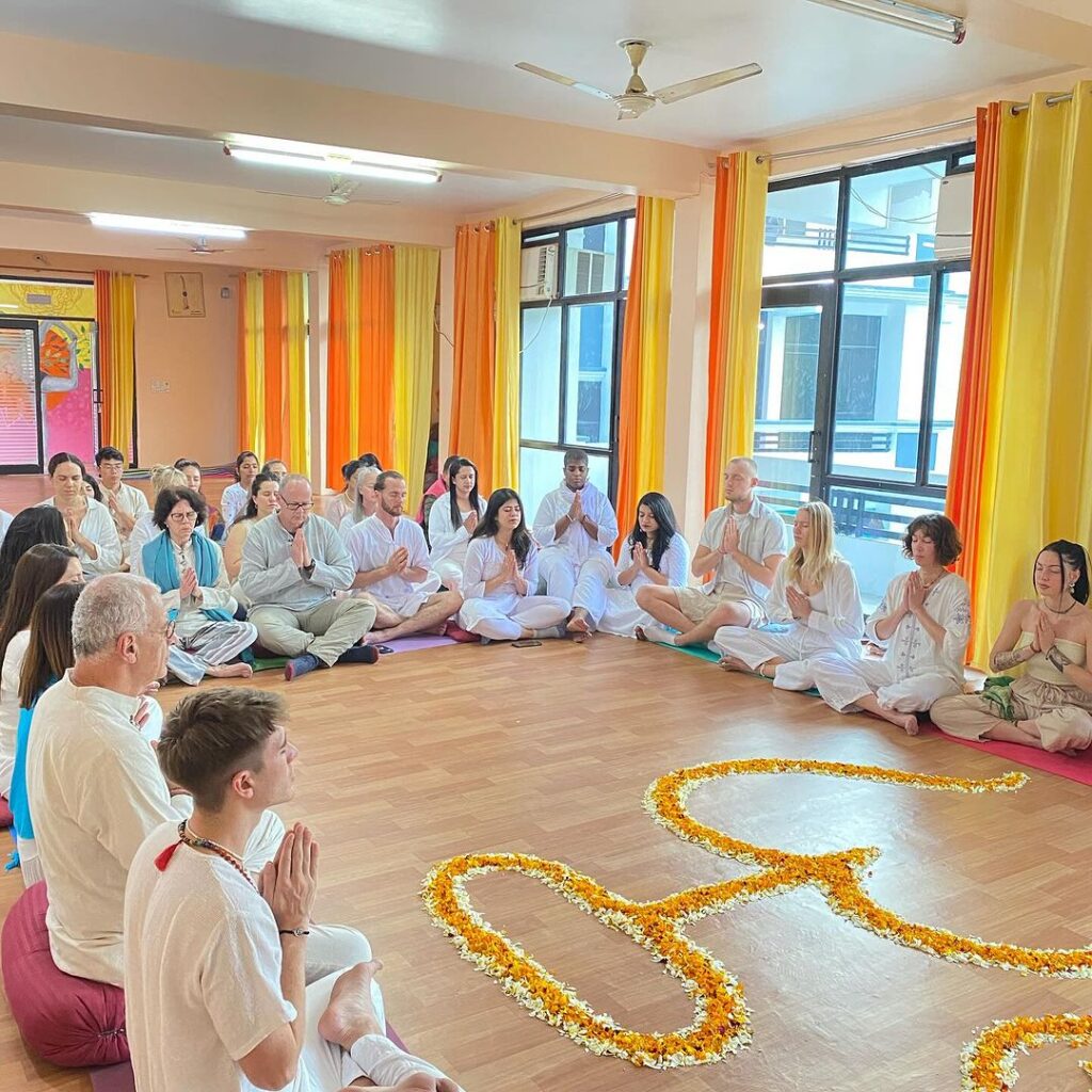 Why Yoga Teacher Training in Rishikesh Is the Greatest Option in India 1 Yoga Teacher Training Students Performing Prayer at Rishikul Yogshala, Rishikesh