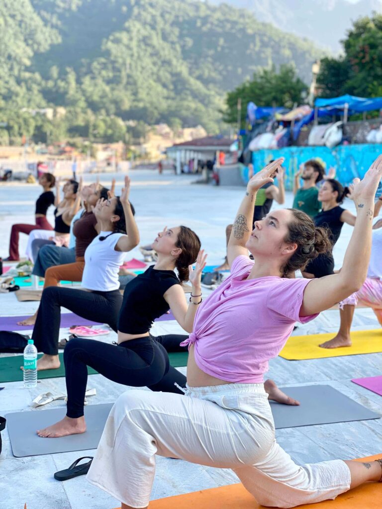 Yoga students practicing low lunge pose during an outdoor session of the yoga teacher training course Yoga students practicing low lunge pose during an outdoor session of the yoga teacher training course