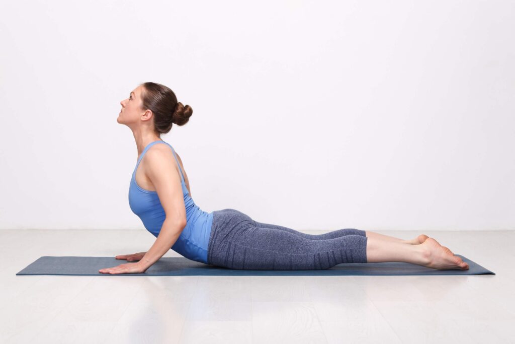 Woman practicing Cobra Pose (Bhujangasana) Woman practicing Cobra Pose (Bhujangasana)