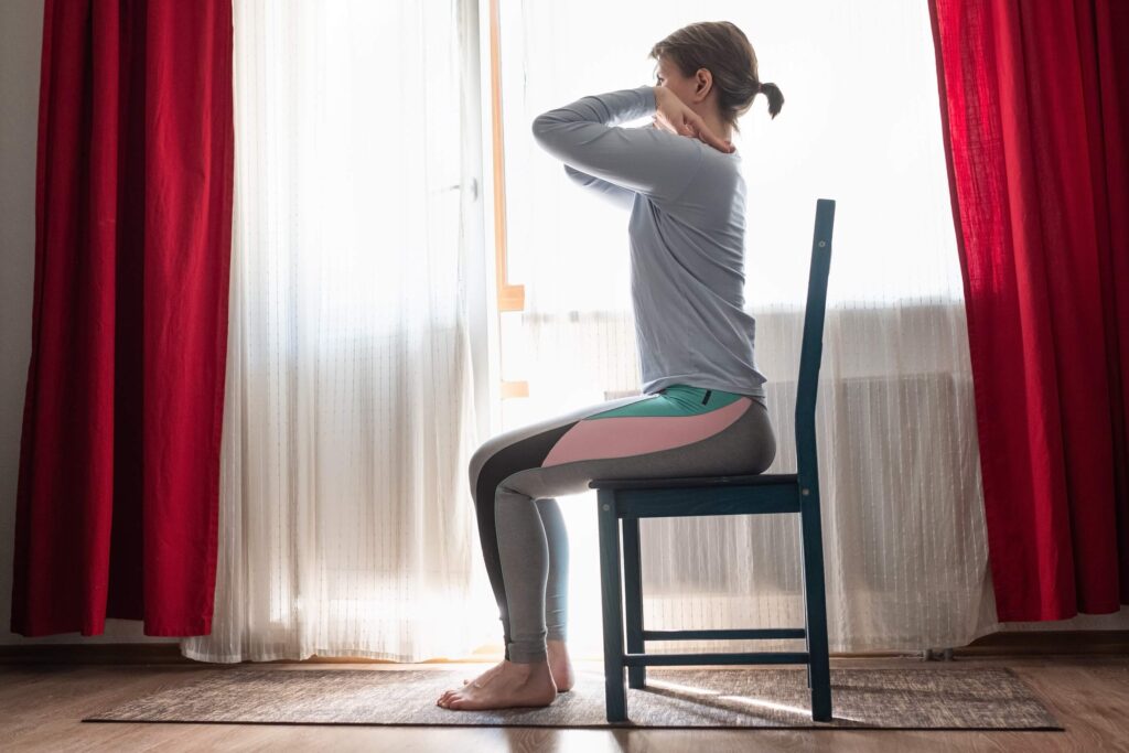 woman practicing seated yoga on a chair