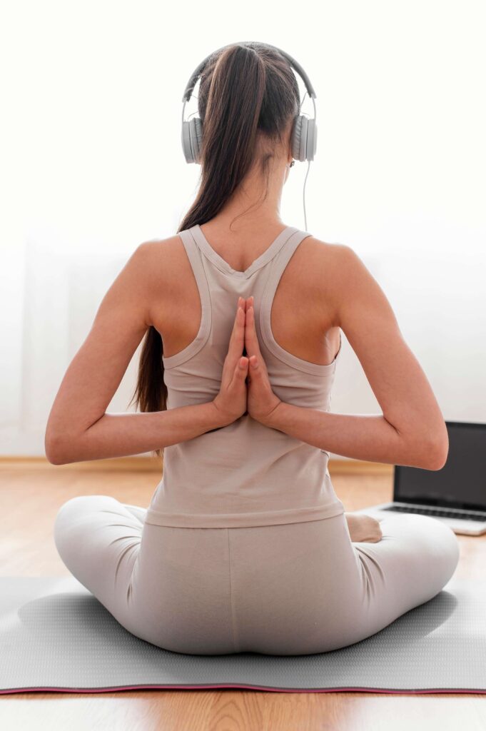 Woman sitting cross-legged on a yoga mat Woman sitting cross-legged on a yoga mat