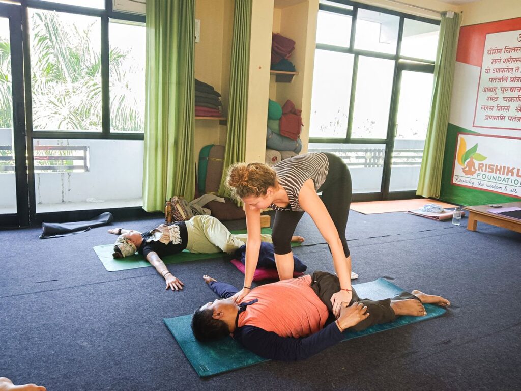 Yoga instructor assisting a student during YTTC at Rishikul Yogshala Yoga instructor assisting a student during YTTC at Rishikul Yogshala