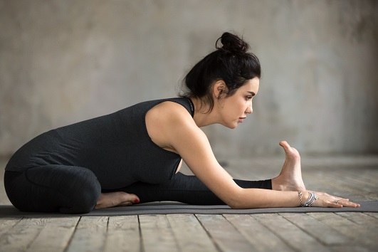 Women Practicing Janu Sirsasana to Improve Spinal Flexibility Women Practicing Janu Sirsasana to Improve Spinal Flexibility