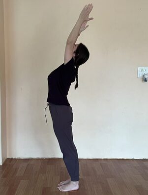 Surya Namaskar: The 12 Poses of Sun Salutation, Step by Step 2 Student Practicing Hasta Uttanasana (Raised Arms Pose) During the 12 Poses of Sun Salutation