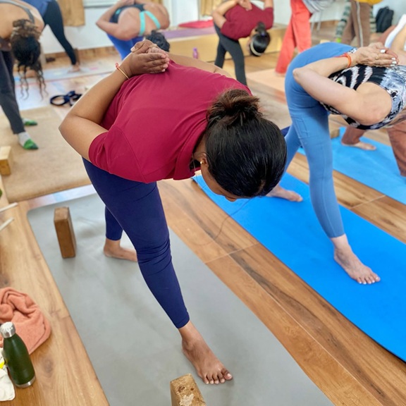 Student Pracising Parsvottanasana (Pyramid Pose) During Yoga Teacher Training in Rishikesh