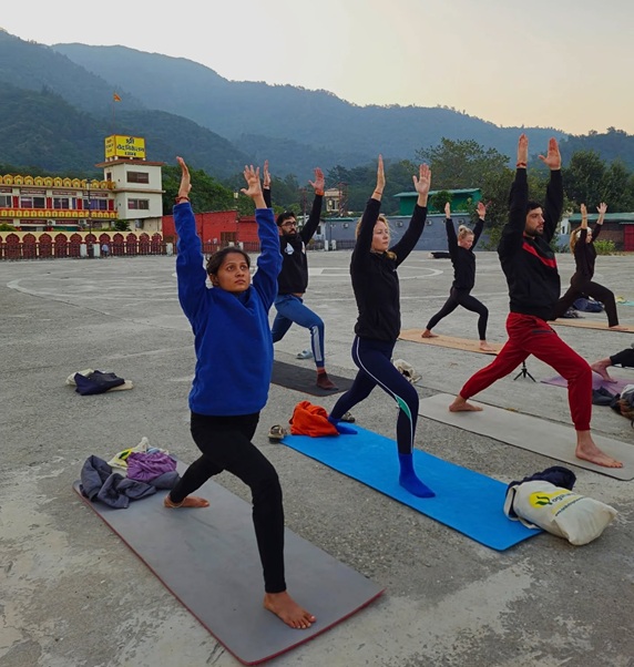 Student Performing Virabhadrasana I (Warrior Pose I) During Yoga Teacher Training in Rishikesh