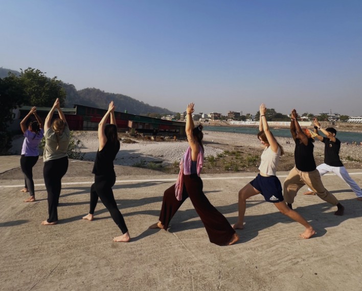 Riverside yoga practice on the banks of the Ganga at Rishikul Yogshala Rishikesh