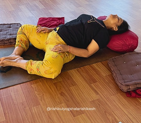 Student Practising Supta Baddha Konasana or Reclining Bound Angle Pose During 200 Hour Yoga Teacher Training in Rishikesh