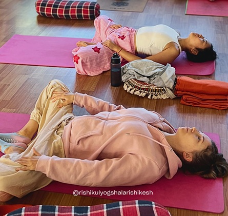 Student Practising Supta Baddha Konasana or Reclining Bound Angle Pose During 200 Hour Yoga Teacher Training in Rishikesh
