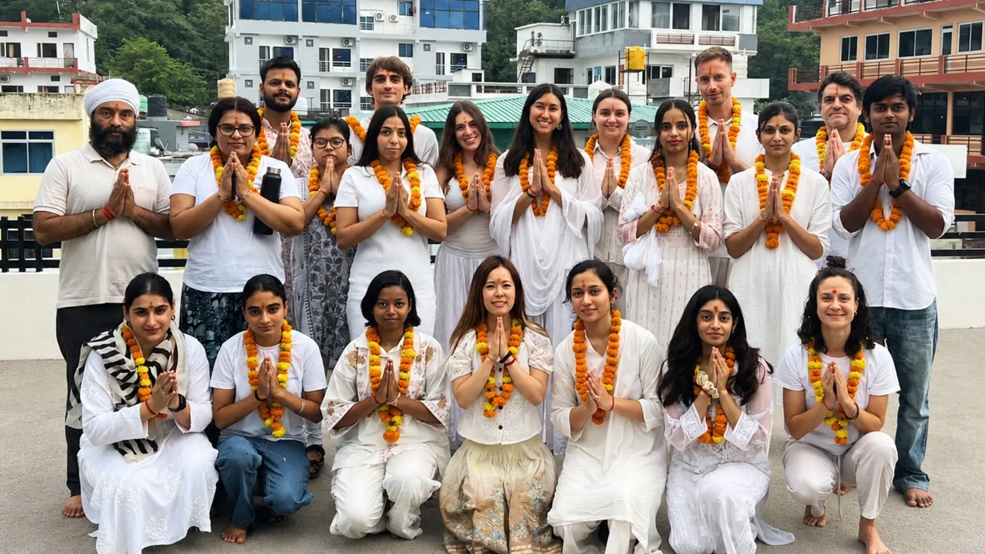 Yoga teacher training students in Namaste with marigold garlands at Rishikul Yogshala Rishikesh